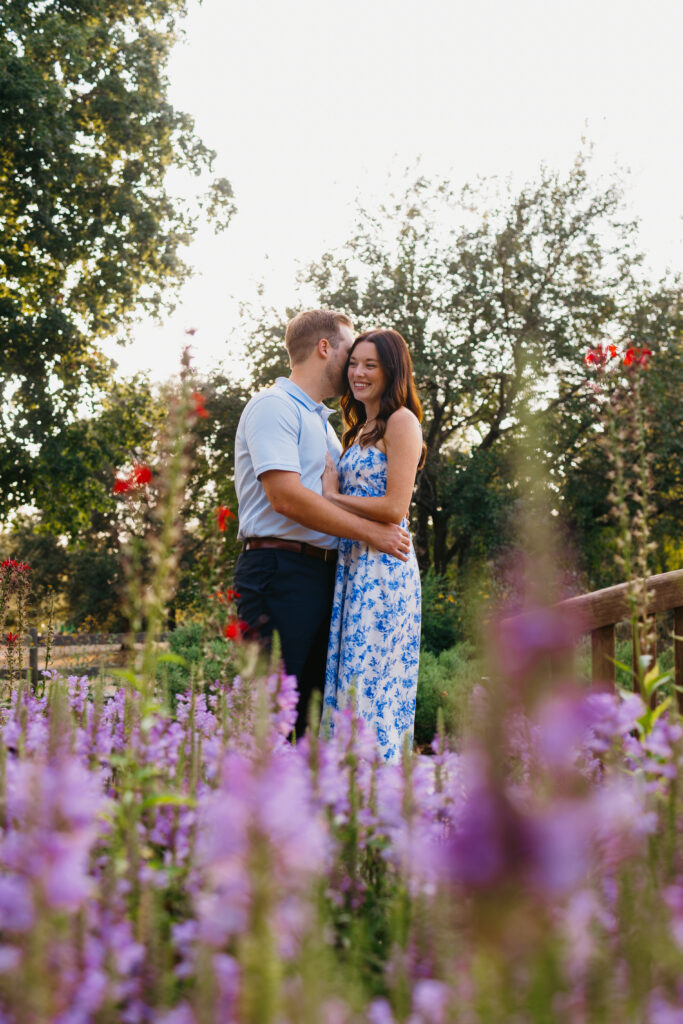 Morgan and Mitch sharing a romantic moment under a flower-covered archway at Franklin Park Conservatory.